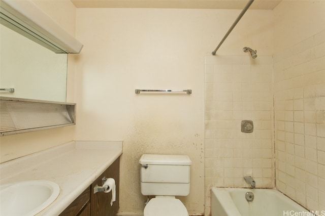 full bathroom with vanity, tiled shower / bath combo, and toilet