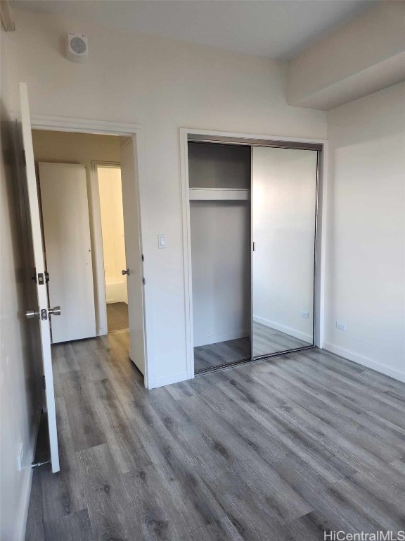 unfurnished bedroom with hardwood / wood-style floors and a closet