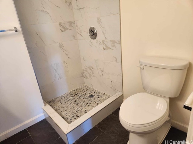 bathroom with tile patterned floors, toilet, and tiled shower