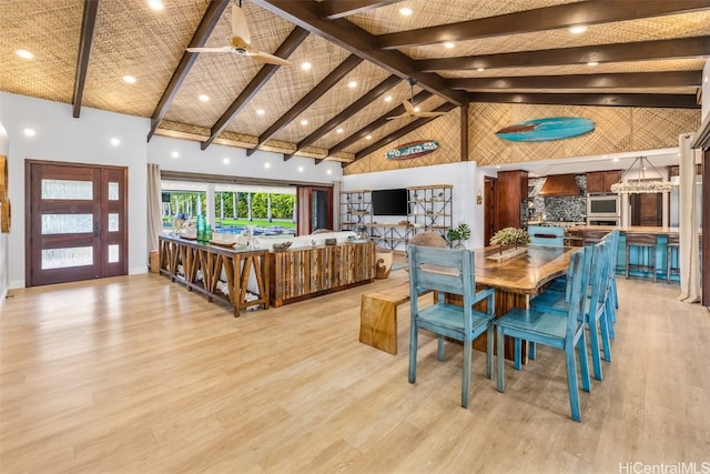 dining space with beamed ceiling, ceiling fan, light hardwood / wood-style floors, and high vaulted ceiling