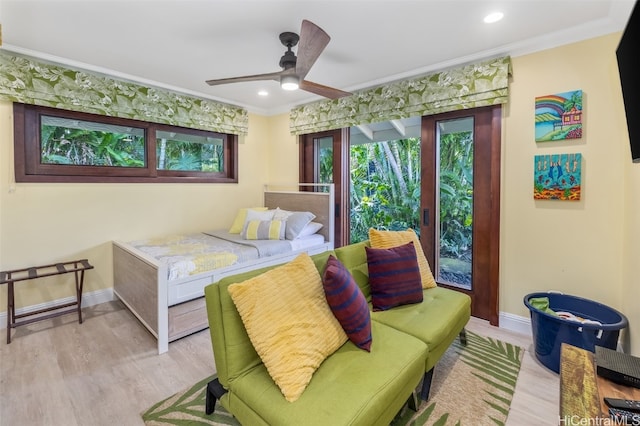 bedroom featuring light wood-type flooring, ceiling fan, and crown molding