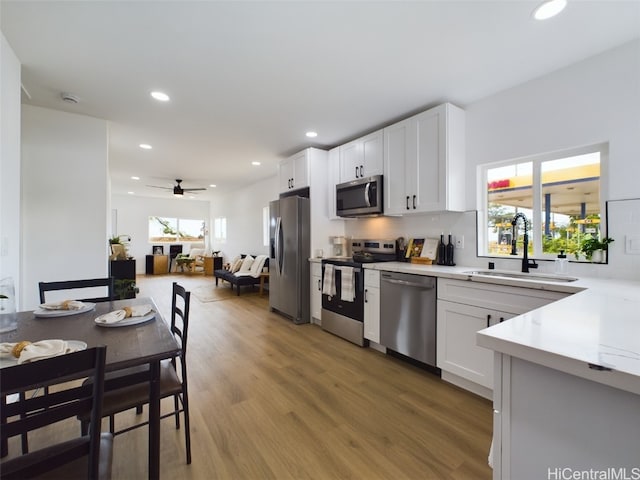 kitchen with stainless steel appliances, white cabinetry, a healthy amount of sunlight, and sink