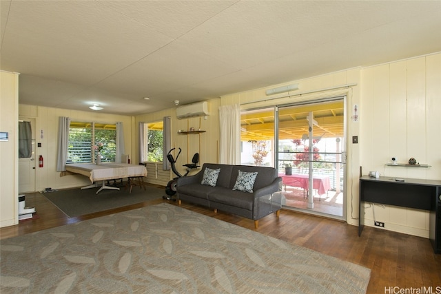 living room featuring a wall unit AC and dark hardwood / wood-style flooring