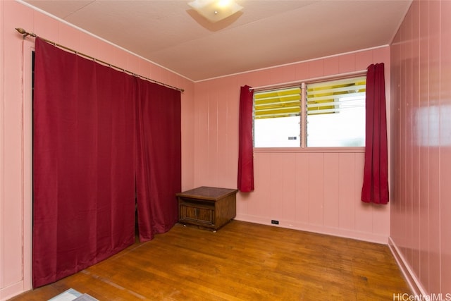 spare room with wooden walls and hardwood / wood-style flooring