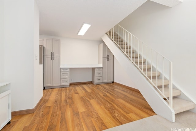 interior space featuring built in desk and light hardwood / wood-style flooring