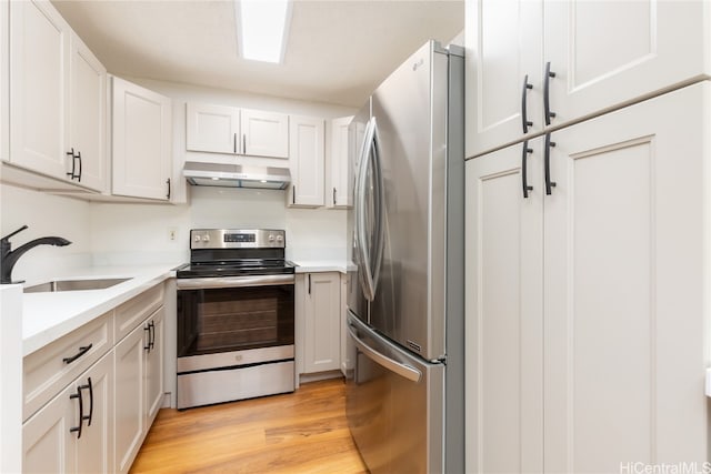 kitchen with white cabinets, light wood-type flooring, sink, and appliances with stainless steel finishes