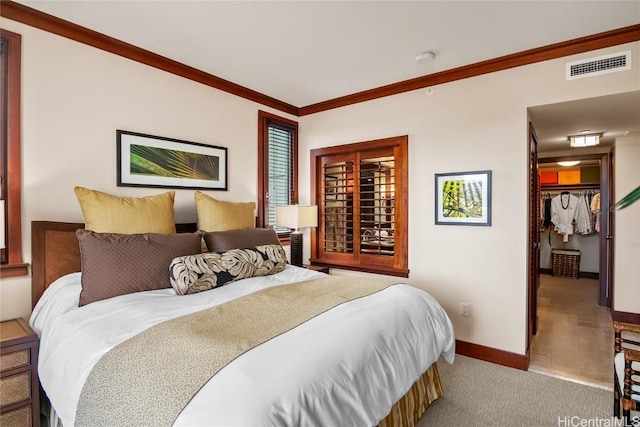 bedroom with visible vents, carpet floors, baseboards, and crown molding