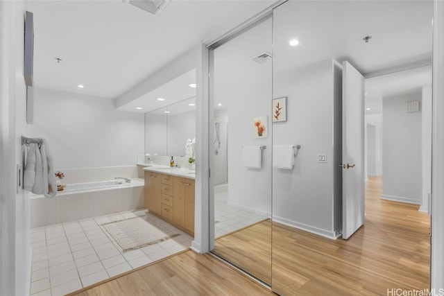 bathroom with vanity, separate shower and tub, and wood-type flooring