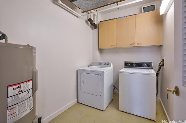 clothes washing area featuring washer and clothes dryer, cabinets, and electric water heater