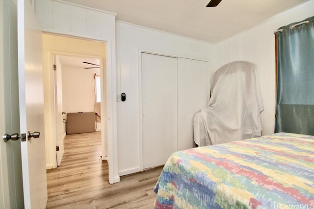 bedroom with a closet, ceiling fan, light hardwood / wood-style flooring, and ornamental molding