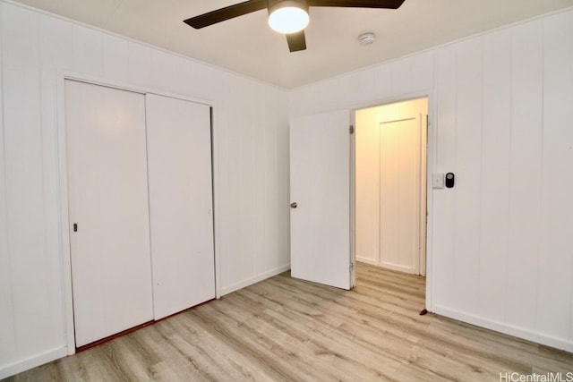 unfurnished bedroom featuring ceiling fan, light wood-type flooring, and a closet