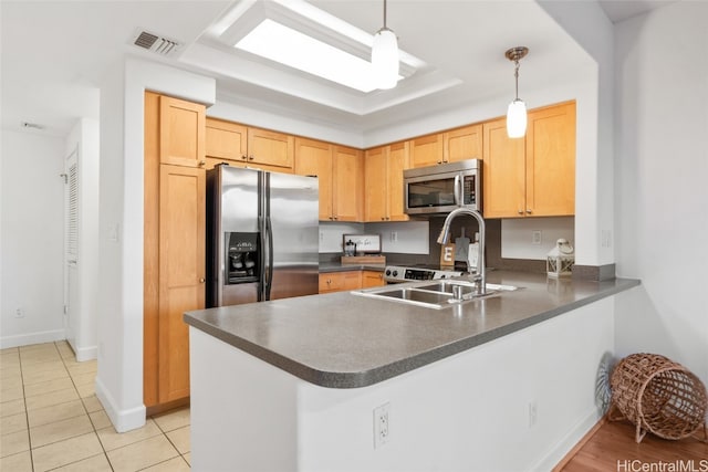 kitchen with kitchen peninsula, appliances with stainless steel finishes, sink, light tile patterned floors, and decorative light fixtures