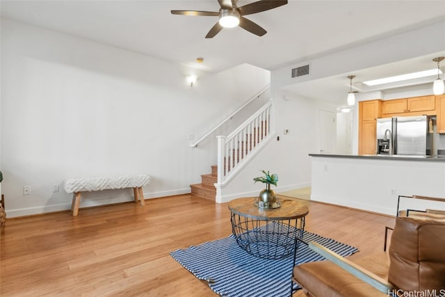 living room featuring ceiling fan and light hardwood / wood-style flooring