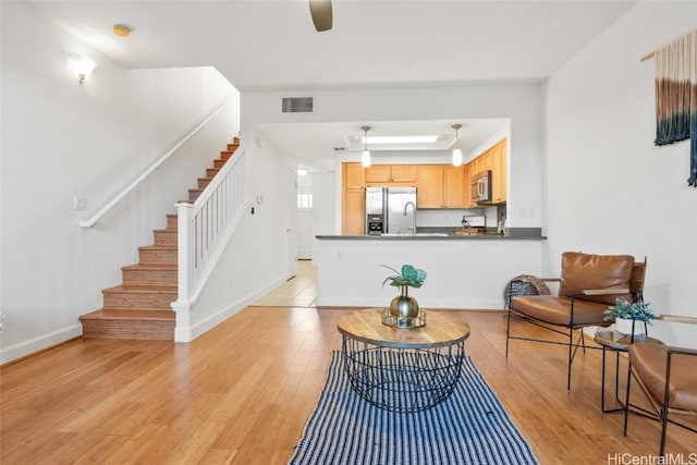 living room with ceiling fan and light wood-type flooring