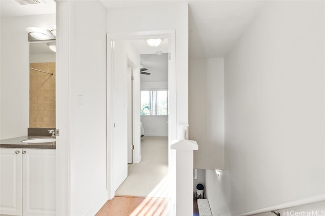 corridor with sink and light hardwood / wood-style flooring