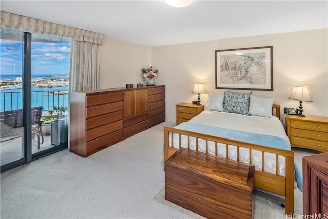 bedroom featuring a water view, light colored carpet, and access to outside