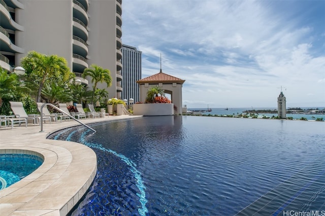 view of swimming pool with a gazebo, a patio, and a water view