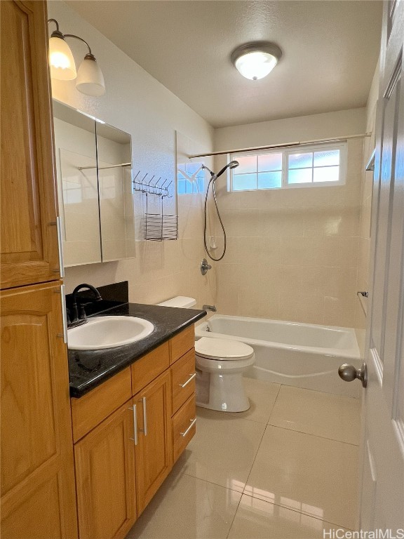 full bathroom featuring tile patterned floors, toilet, vanity, and tiled shower / bath