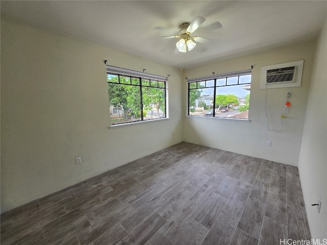 unfurnished room featuring a wall mounted AC, ceiling fan, and dark hardwood / wood-style floors