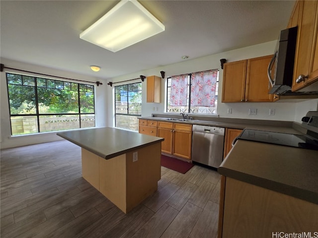 kitchen featuring a breakfast bar, sink, dark hardwood / wood-style floors, appliances with stainless steel finishes, and a kitchen island