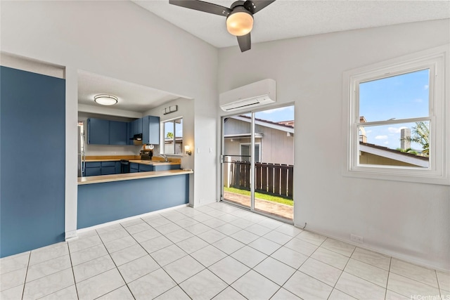 98-519 Lulu Pl Unit 73, Aiea, HI 96701 - kitchen with blue cabinetry, an AC wall unit, range with electric stovetop, ceiling fan, and light countertops