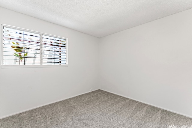 carpeted empty room featuring a textured ceiling