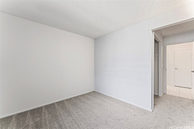 carpeted spare room with a textured ceiling