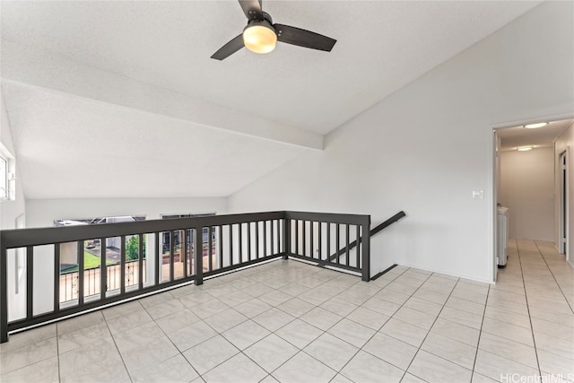 tiled empty room with beam ceiling, ceiling fan, high vaulted ceiling, and a textured ceiling