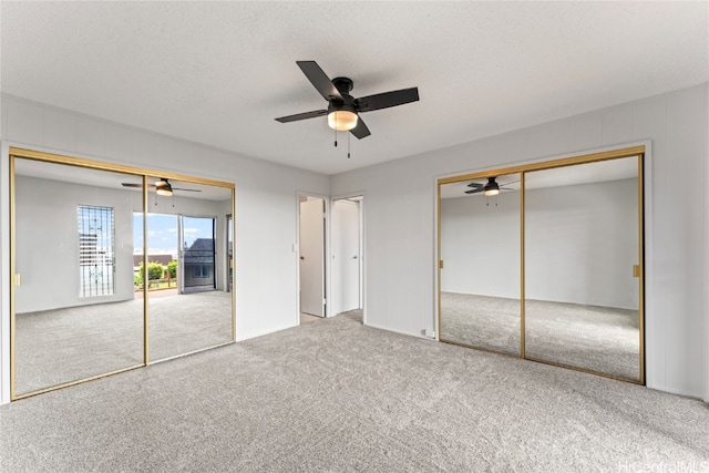 unfurnished bedroom featuring ceiling fan, carpet floors, and a textured ceiling