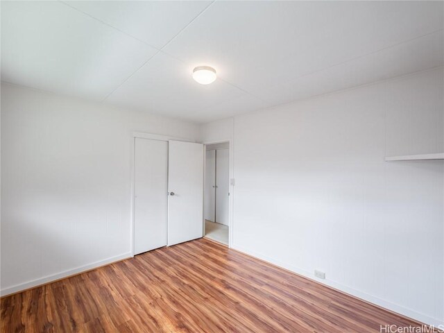 unfurnished bedroom featuring hardwood / wood-style floors and a closet