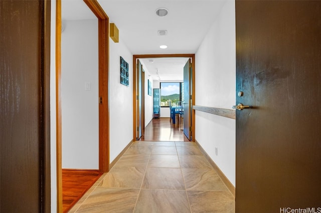 hallway with a wall of windows and baseboards