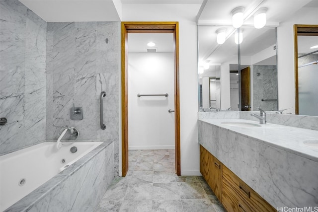 full bath featuring a sink, baseboards, double vanity, a tub with jets, and walk in shower