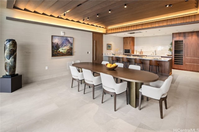 dining area with wood ceiling and rail lighting