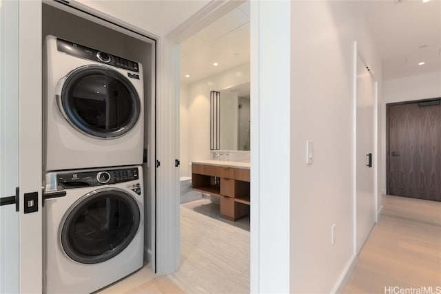 laundry area with light wood-type flooring and stacked washing maching and dryer