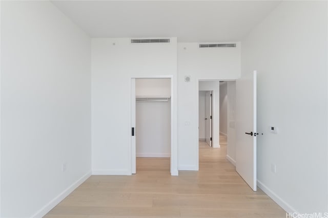 unfurnished bedroom featuring light hardwood / wood-style flooring and a closet