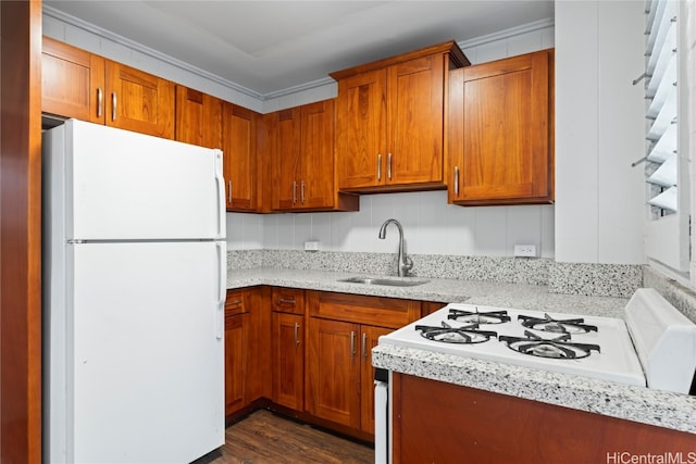 kitchen featuring dark hardwood / wood-style flooring, light stone counters, ornamental molding, sink, and white refrigerator