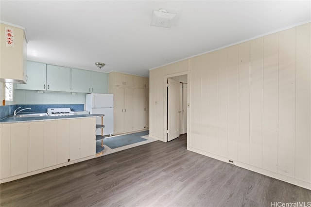 kitchen with white appliances, white cabinetry, dark wood-type flooring, and sink