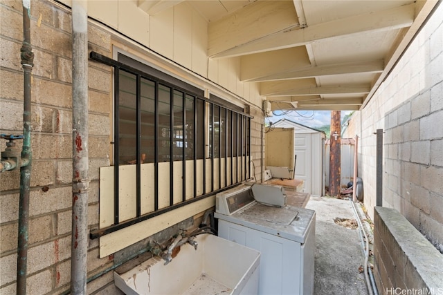 view of side of property featuring washing machine and clothes dryer and a storage unit