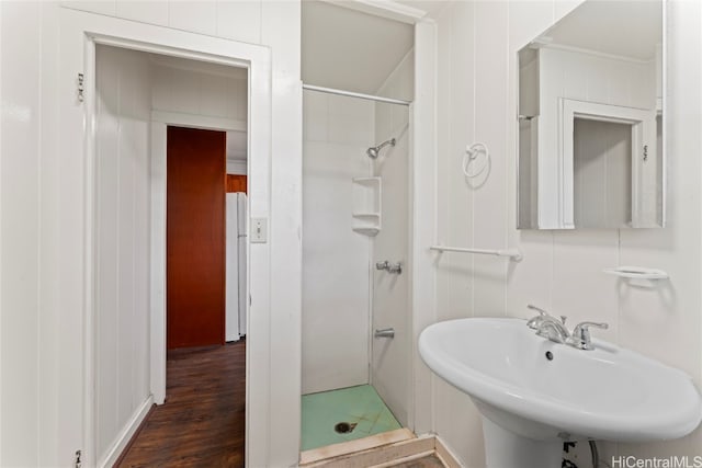 bathroom with a shower, hardwood / wood-style floors, and sink