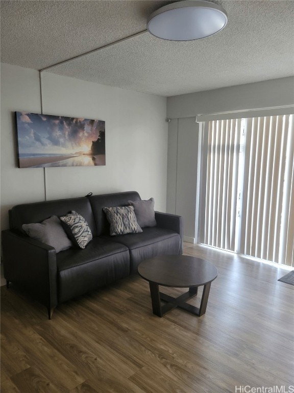 living room with wood-type flooring and a textured ceiling