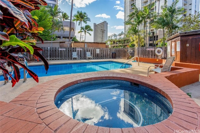 view of pool featuring a hot tub and a patio area