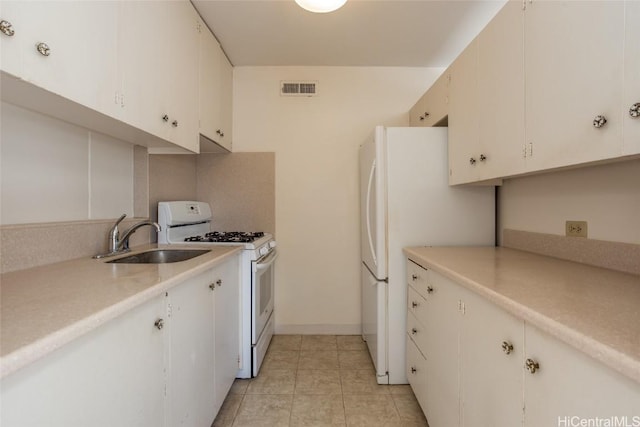 kitchen with sink, white cabinets, white appliances, and light tile patterned floors