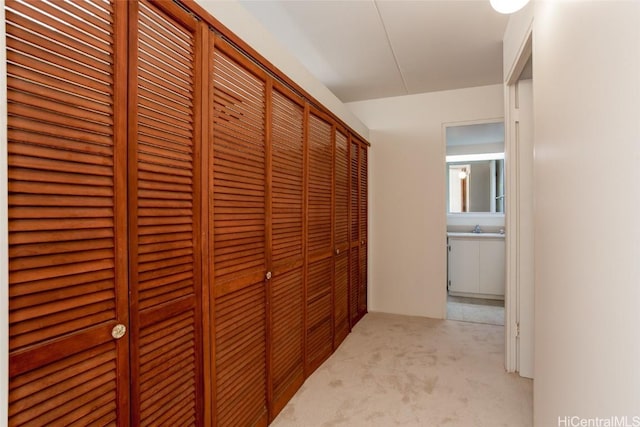 hall with light carpet and sink