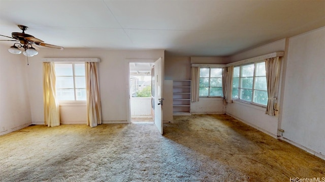 carpeted spare room featuring ceiling fan