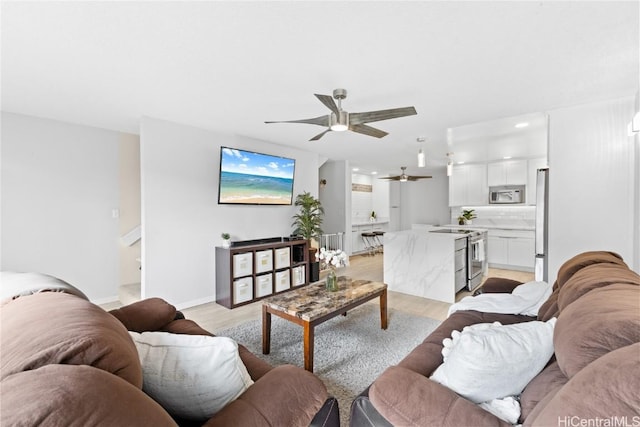 living room featuring light hardwood / wood-style flooring and ceiling fan