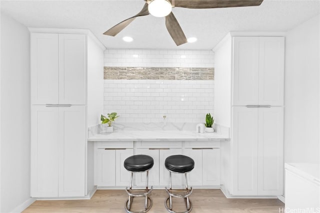 interior space featuring light stone counters and white cabinetry