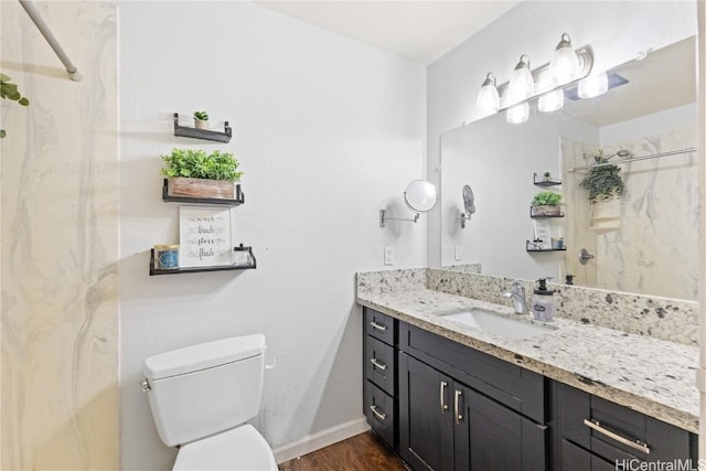 bathroom with hardwood / wood-style flooring, vanity, toilet, and walk in shower