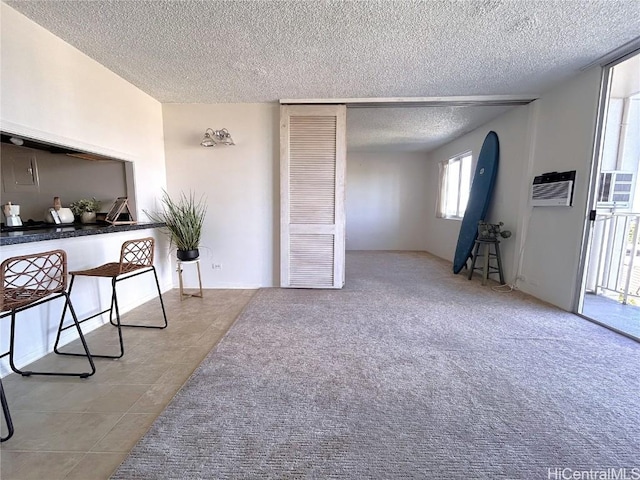 office with a textured ceiling, a wall mounted AC, and light tile patterned flooring