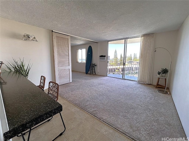 living room with light carpet, a textured ceiling, and a wall mounted air conditioner