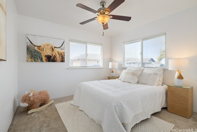 carpeted bedroom featuring multiple windows and ceiling fan